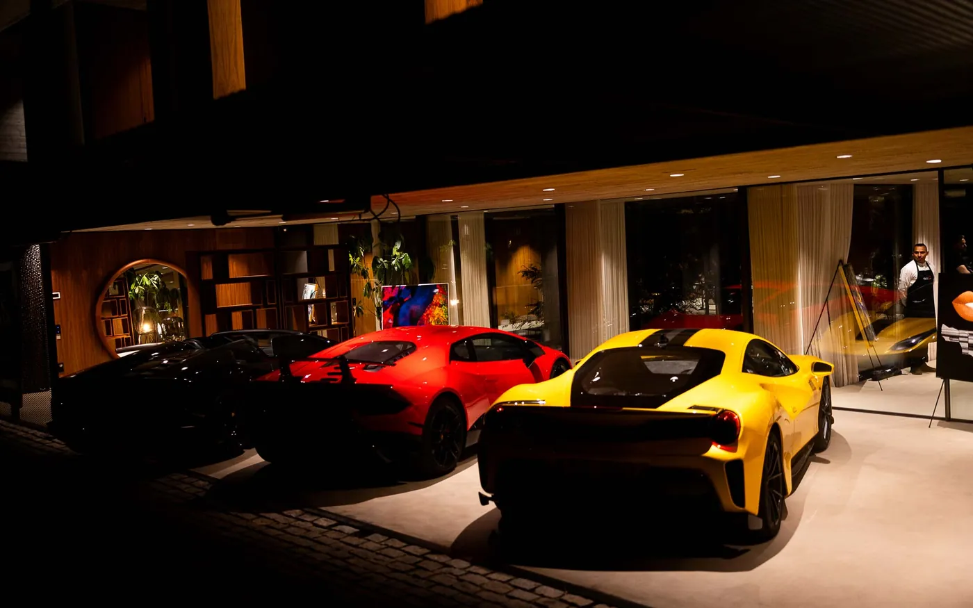 Supercars parked at night outside a lit Marbella venue